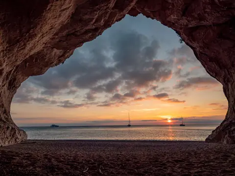 Alba vista da una grotta costiera